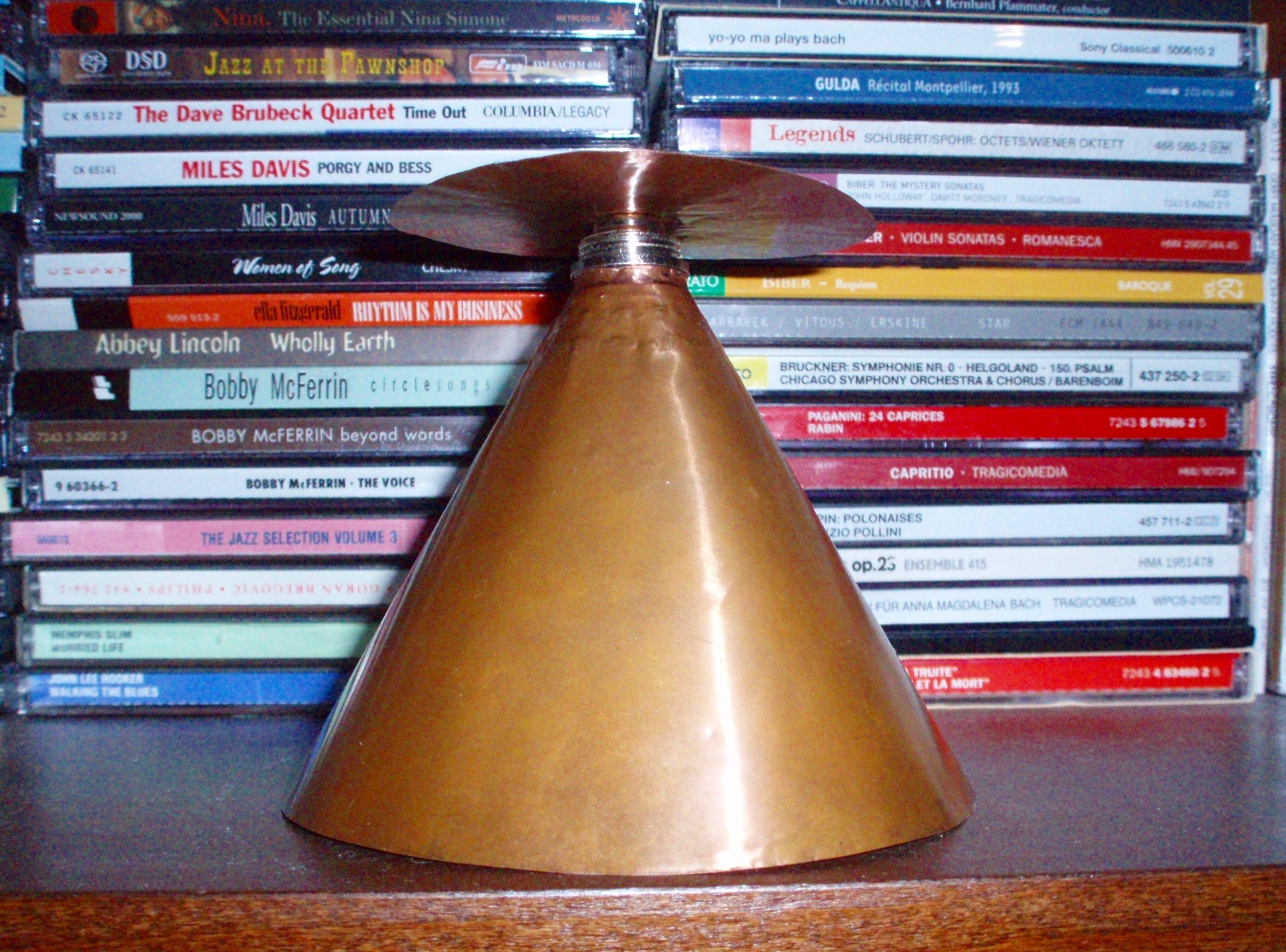 Figure 1 — A discone built from solid copper sheet, photographed in side view: a flat circular disc above a solid cone, separated by a short insulated feed gap. This is the antenna whose silhouette was measur…